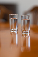 Two glasses full of water on a brown table