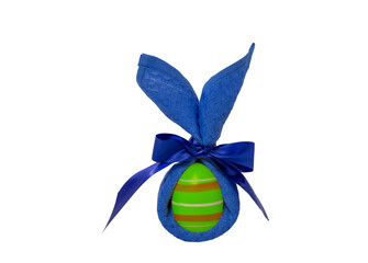 A painted egg wrapped in a blue napkin in the shape of ears is isolated on a white background.
