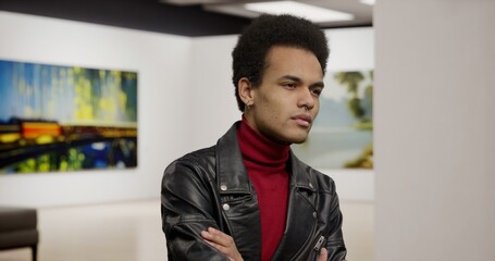 Portrait of 20s African-American male engaging with Art at an Exhibition. Modern fine arts museum. Model and property released