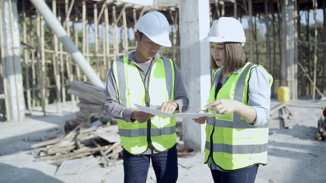 Two specialists inspect commercial, Industrial building construction site. Real estate project with civil engineer, designing commercial buildings on paper.
