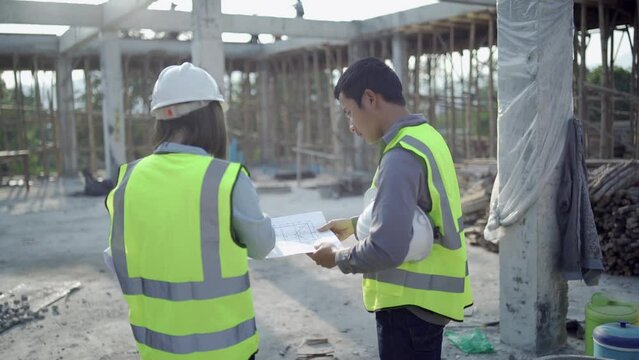Two specialists inspect commercial, Industrial building construction site. Real estate project with civil engineer, designing commercial buildings on paper.