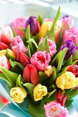 Multicolor tulips bouquet close up in vase on white background