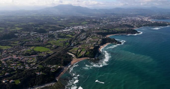 Aerial Drone View of French Basque Country Coastline close to Biarritz, France with many Basque houses in the coastal towns and ocean waves breaking on reefs