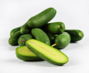 Cut and whole seedless mini avocados isolated on white. A group of mini avocado or cocktail avocado...