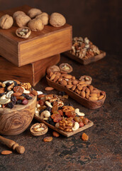 Fototapeta na wymiar Mix of nuts and raisins on a brown rustic background.