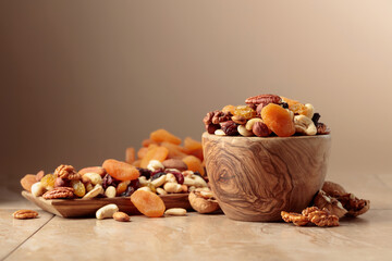 Plakat Dried fruits and nuts on a beige ceramic table.