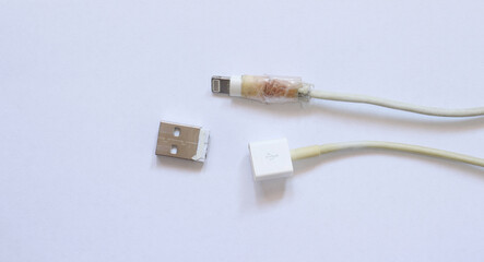 Old broken charger cable on white background