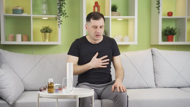 Man with shortness of breath and chest tightness.
The man who has chest tightness and shortness of breath at home is suffocating and suffering.
