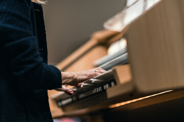 A musician playing a digital organ with three manuals