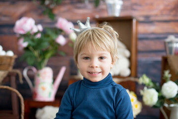 Beautiful toddler blond boy, wearing little crown, pretending to be prince