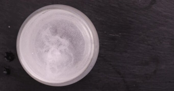 A tablet soluble in a glass of water, a large number of bubbles in the water from a tablet that is dissolved in water