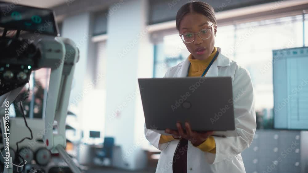 Leinwandbilder young black female engineer testing industrial programmable robot animal in a factory development wo