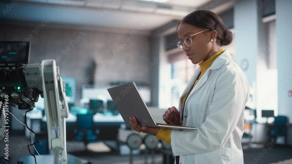 Aufkleber tracking portrait of young black female specialist in lab coat using laptop computer to test an ai r
