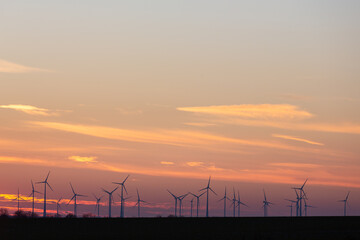 Wind turbines generate energy power electricity during the evening. Sunset, Silhouettes, wind turbines, clean energy