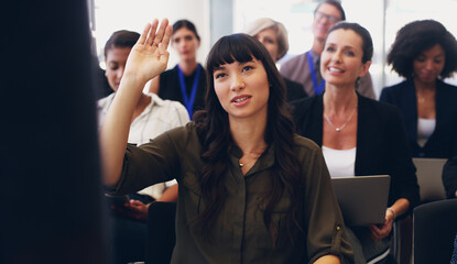 I have so many questions. Cropped shot of an attractive young businesswoman sitting with her diverse colleagues and raising her hand while in the office.
