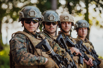 Fototapeta premium Soldier fighters standing together with guns. Group portrait of US army elite members, private military company servicemen, anti terrorist squad
