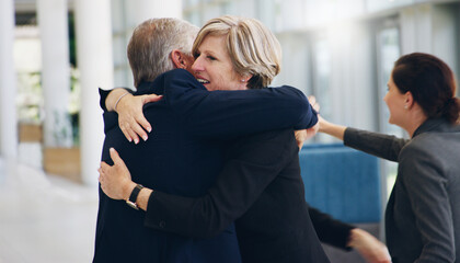 Congratulations You did it. Cropped shot of two mature businesspeople hugging each other while in the office during the day.