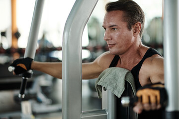 Positive fit man working out in gym in the morning