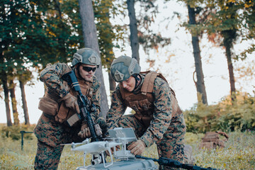 Fototapeta premium Modern Warfare Soldiers Squad are Using Drone for Scouting and Surveillance During Military Operation in the Forest.