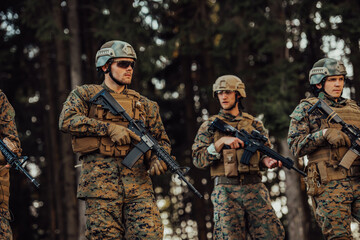 Fototapeta premium Soldier fighters standing together with guns. Group portrait of US army elite members, private military company servicemen, anti terrorist squad