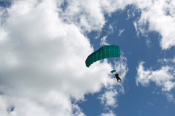 two-person parachute descent seen from below