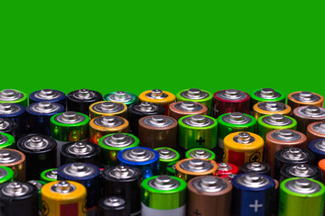 Used different batteries. Close-up. Copy space.Green background. Waste sorting concept. Ecology.