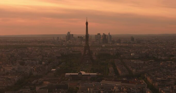 Panoramic aerial view of Paris cityscape with Eiffel Tower and major business district of La Defence in background As the video view of golden sun sets behind the Paris city, lle de France