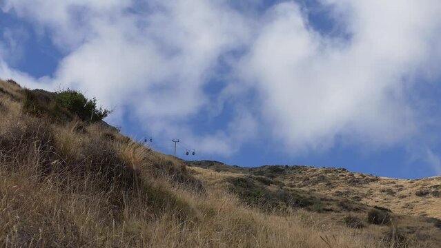 Gondola cars appear tiny as clouds rush past - Heathcote Valley, Christchurch (New Zealand)
