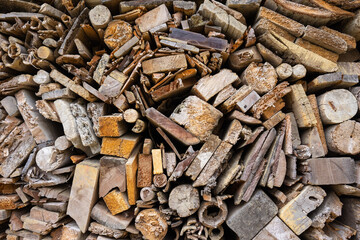 Background from stacked wooden boards of different shapes. Full surface texture of end pieces of wood pieces in shades of brown.