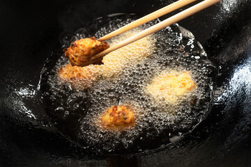 揚げたての揚げ物と調理中の油の入った天ぷら鍋 -...