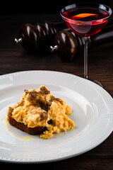 Rye bread toast with fried scrambled egg and onions with a glass of drink.