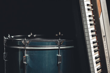 Fototapeta na wymiar Drum and musical keys on a black background, close up.