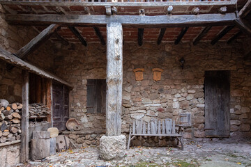 Rustic porch of a stone house with wooden elements.