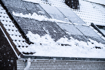 Mit Schnee bedeckte Solarpanele auf dem Dach eines Hauses in Essen, NRW