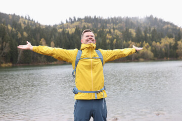 Happy tourist reaches his destination with outstretched arms.