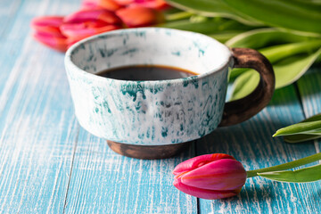 Spring composition with a cup of coffee and tulips.