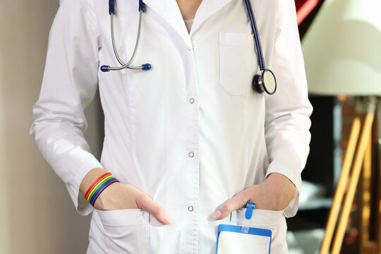 Cropped image of doctor with lgbt bracelet on her hand.
