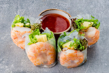 Rice paper rolls with shrimp, rice noodles, mango, lettuce and sauce.