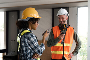 Female male engineers holding walkie talkie radios and inspecting construction site