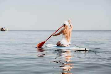 Woman sea sup. Close up portrait of happy young caucasian woman with long hair looking at camera and smiling. Cute woman portrait in bikini posing on sup board in the sea