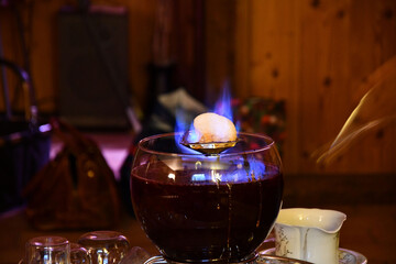 Burning sugarloaf over a bowl of Feuerzangenbowle on a restaurant table