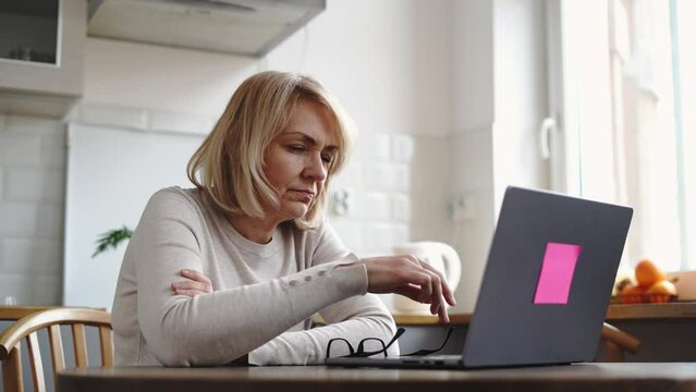 Mature woman sad with laptop at home. Finance problems 