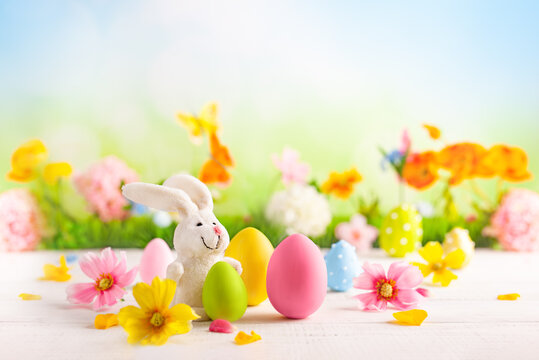 Happy Easter greeting card. Easter eggs, bunny  and spring flowers on table for decoration home for Easter.
