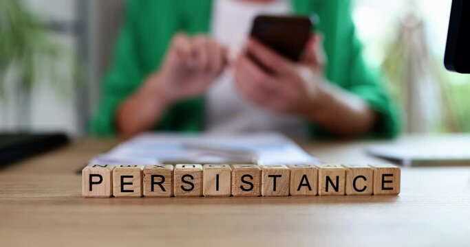 Business woman smartphone text on cubes persistence