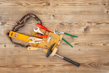 Eine Werkzeugtasche mit viel Werkzeug auf einem Holzboden