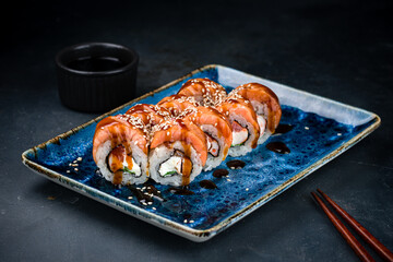 Set of Japanese sushi rolls with salmon, shrimp, cream cheese, lettuce, sesame and teriyaki sauce.