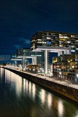Aerial view of illuminated crane houses by the canal at the Zollhafen in Cologne, Germany at night