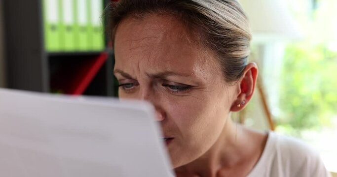 Portrait of worried woman reading paper letter