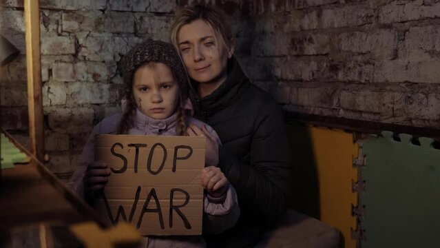 Bomb shelter. War in Ukraine. Gunning of civilians. Ukrainian family sits in a bomb shelter. Bombardment. Military action. Stop war. Crisis in Ukraine, aggression, child against war.