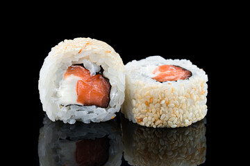 Sushi rolls with salmon, cream cheese in sesame seeds.